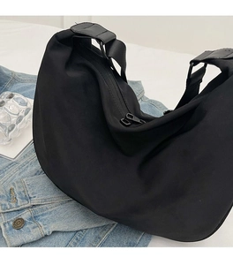 Detail view of soft waterproof black nylon crescent bag with adjustable wide shoulder strap