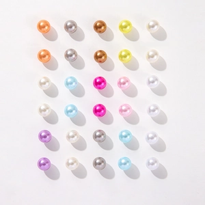 Set of colorful faux pearl stud earrings in 15 vibrant shades on white background