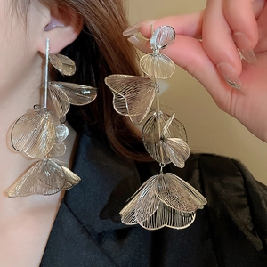 Detail of silver brushed metal flower tassel earrings with layered hollow petals