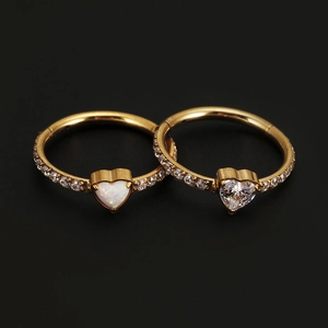 Detailed shot of golden seamless rings with heart-shaped opal and clear zircon stones