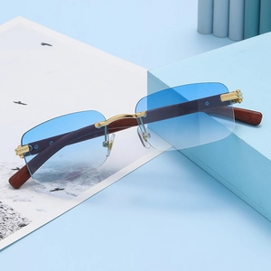Detalle de lentes azules degradadas sin montura con puente dorado y varillas de madera