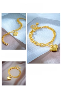 Detail of gold heart pendant and dual-style cuban link chain with OT clasp closure