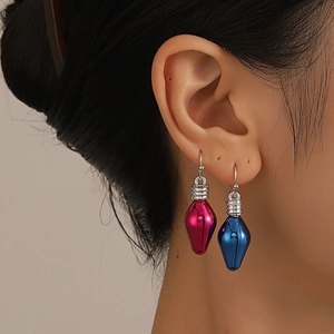 Close-up of a model wearing creative magenta and dark blue bulb pendant earrings