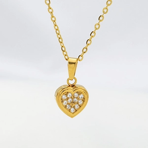 Macro detail of a gold heart pendant necklace with micro-set sparkling zircon stones