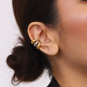 Dettaglio di ear cuff bicolore oro e argento intrecciati sull'orecchio di una modella