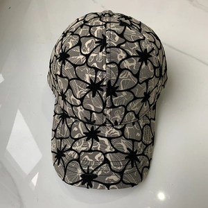 Floral print baseball cap with black and white sketches on white marble background