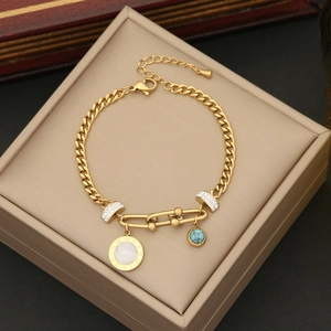 Gros plan d'un bracelet doré avec chiffres romains et pendentifs turquoise sur boîte