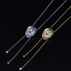 Detailed close-up of gold and silver bolo ties with quilted slider and teardrop gem