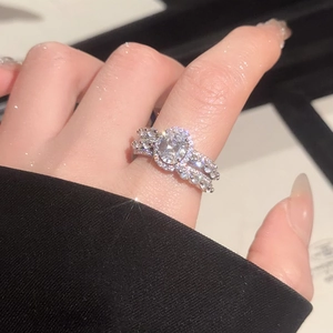 Detailed view of an elegant oval zircon and pearl halo ring with a silver-tone finish