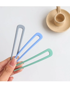 Detailed view of matte U-shaped hairpins in blue and green held by a person