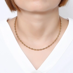 Waterproof gold stainless steel 3:1 beaded chain necklace shown on model's neck