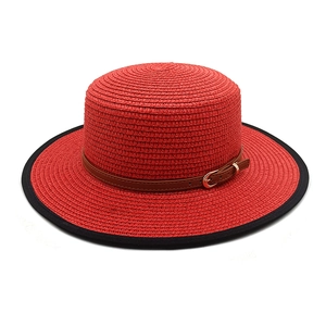 Détail d'un chapeau de paille rouge à toit plat avec ceinture en cuir et boucle