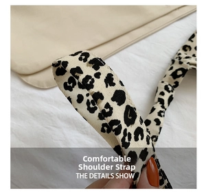 Dettaglio di una larga tracolla leopardata su una borsa in pelle beige testurizzata