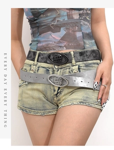 Detail of vintage glitter belts with oval globe buckles on denim shorts
