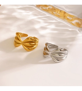 Detail view of 18K gold and silver bow rings with elegant water ripple shadow reflections