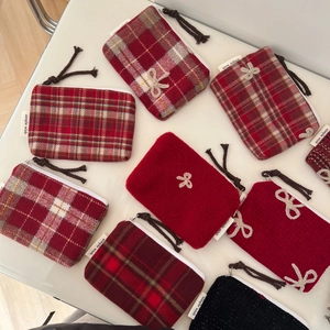 Flat lay of red plaid and knitted coin purses with bow knots and simple wish labels