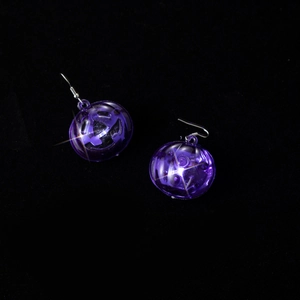 Macro detail of purple transparent bead earrings with internal clockwork gear mechanism