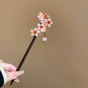 Detailed view of pink floral hair stick with wooden body and hanging white pearl charm