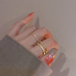 Close-up of elegant double-layered gold plated ring with white enamel on a model hand