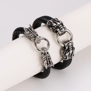 Men's braided leather bracelet with antique silver wolf head metal clasps on white stand