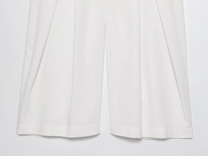 Close-up of white wide-leg trousers showing premium cotton linen texture and hem details
