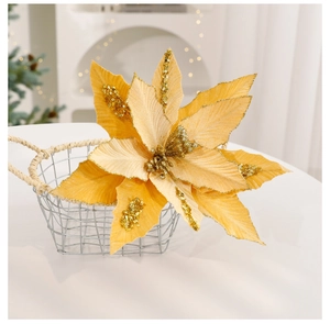 Detail of a golden artificial poinsettia with glitter petals in a festive setting