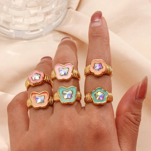 Detail of colorful enamel butterfly and flower rings with gold texture on hand