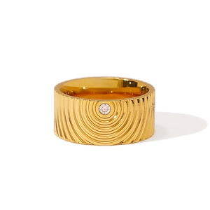 Bague large dorée avec texture concentrique et pierre de zircone centrale