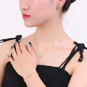 Parure de bijoux dorés avec marguerites vert menthe et pendentifs feuille d'érable