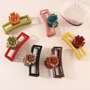 Dettaglio di varie pinze per capelli colorate con rose in resina in rilievo