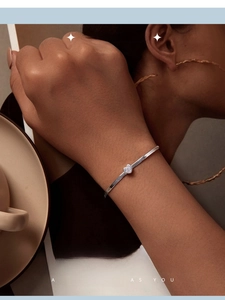 Detail of silver heart bracelet with clear cubic zirconia on snake chain worn on wrist
