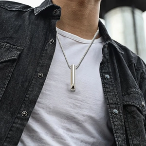 Dettaglio della collana con fischietto respiratorio cilindrico argento su un modello