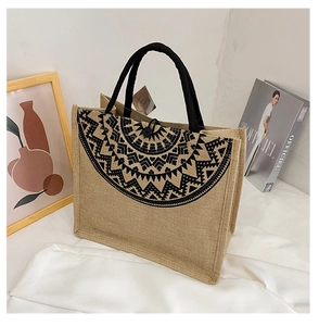 Detail of bohemian jute tote bag featuring geometric tribal pattern and rope handles