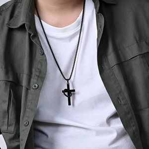 Unisex black stainless steel cross pendant necklace with ring detail on a male model