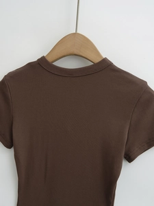 Gros plan du t-shirt marron ajusté montrant la texture en maille côtelée fine