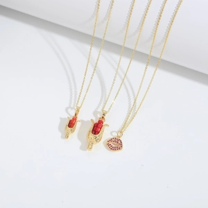Golden goblet necklaces with red beaded seeds and zircon lip pendants on white background