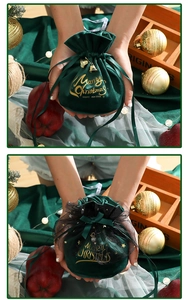 Detail of green velvet Christmas gift bags with gold Merry Christmas print and bells