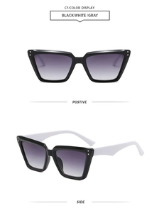 Detail view of cat eye sunglasses with black and white frame and grey gradient lenses