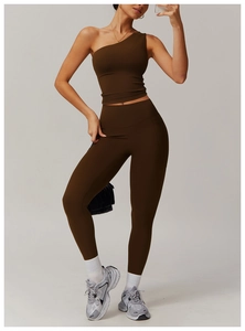 Détail d'un ensemble de yoga marron foncé avec brassière asymétrique et legging taille haute