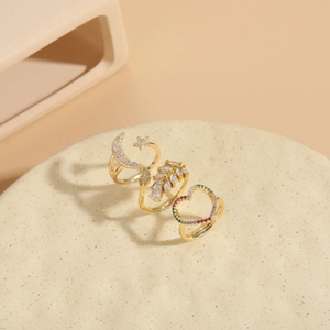Detail of 14K gold plated rings featuring celestial moon, star and zircon leaf designs