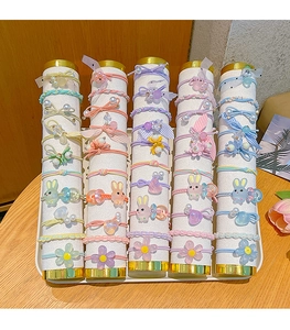 Detail of colorful elastic hair bands with bows and cartoon charms on display stands