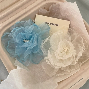 Elegant camellia hair clips in blue and white mesh fabric inside an accessories gift box