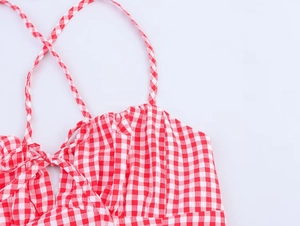 Nahaufnahme des rot-weißen Gingham-Oberteils mit Spaghetti-Trägern und einer Schleife vorne
