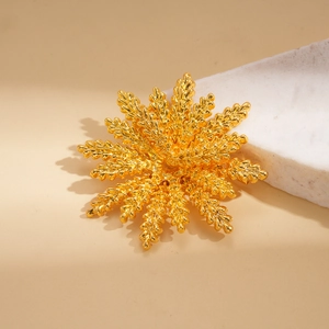 Macro detail of golden snowflake brooch with intricate granular metal texture
