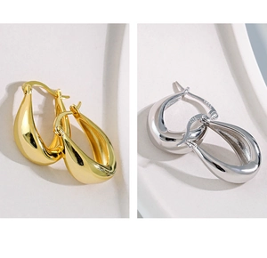 Close-up of minimalist U-shaped S925 silver earrings in gold and silver finish