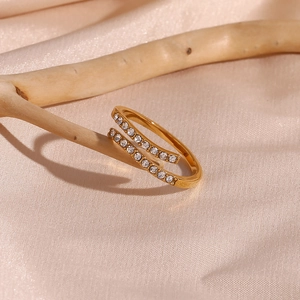 Gold-plated double-layer crossover ring with clear cubic zirconia on pink silk background