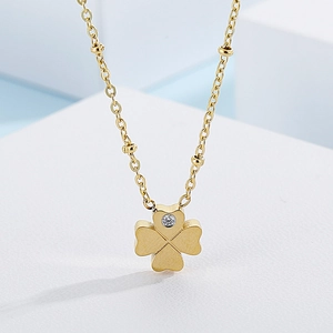 Golden clover pendant necklace with small diamond inlay on white geometric stand