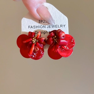 Detailed view of red flower earrings with gold bead center on S925 silver studs