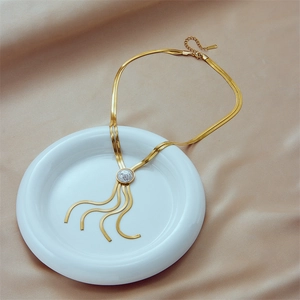 Collana multistrato in titanio dorato con pendente di perla e nappe su seta beige