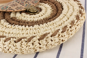 Detailed close-up of woven paper rope bag featuring vintage bronze buckle and boho print